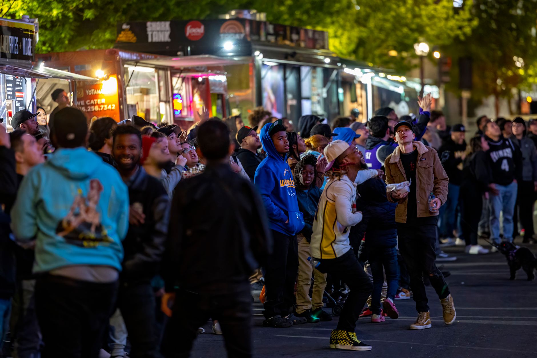 Pessoas reunidas em frente a food trucks